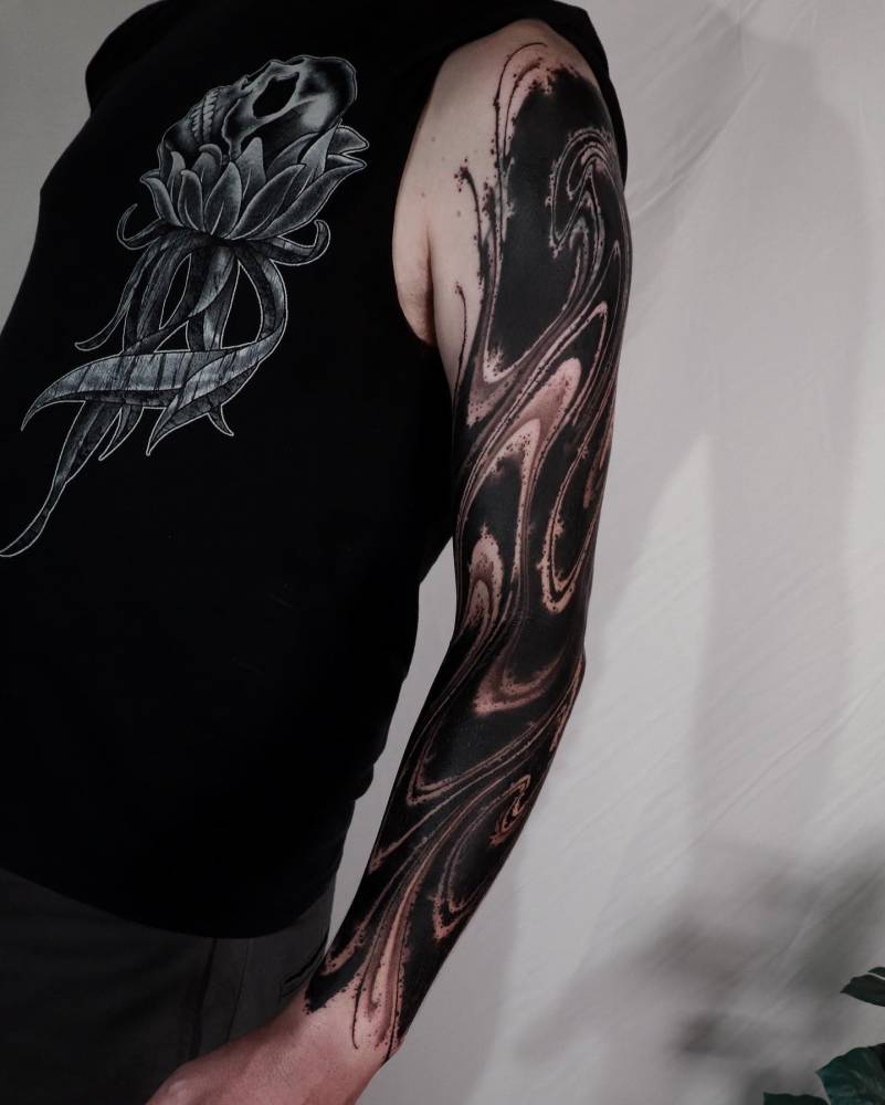 Abstract tattoo sleeve done in blackwork style.