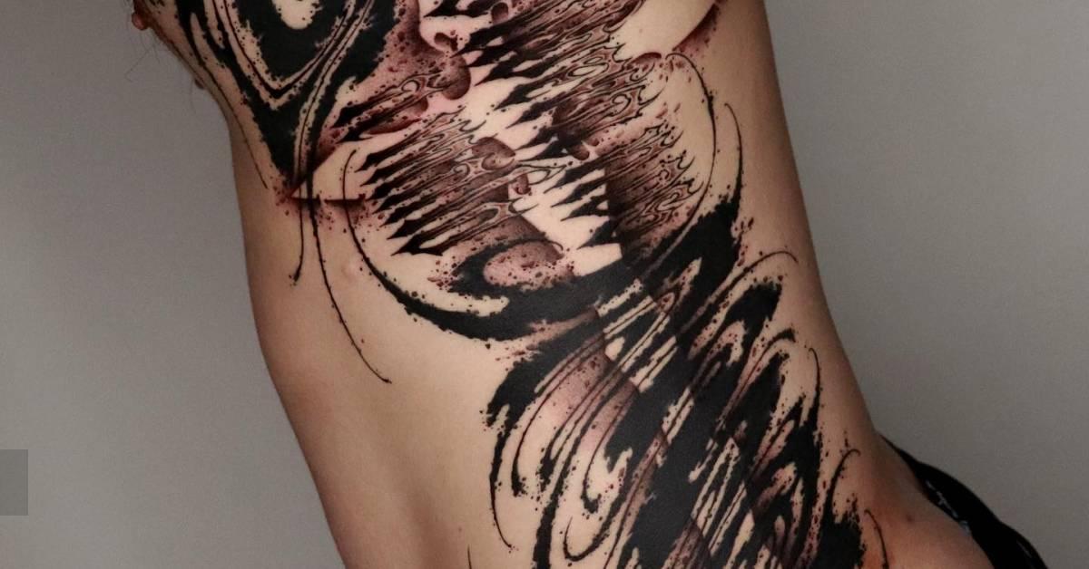 Abstract lettering flow tattoo in blackwork style.