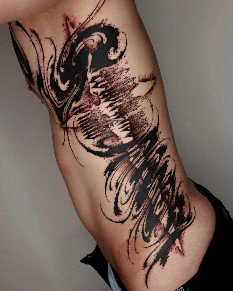 Abstract lettering flow tattoo in blackwork style.