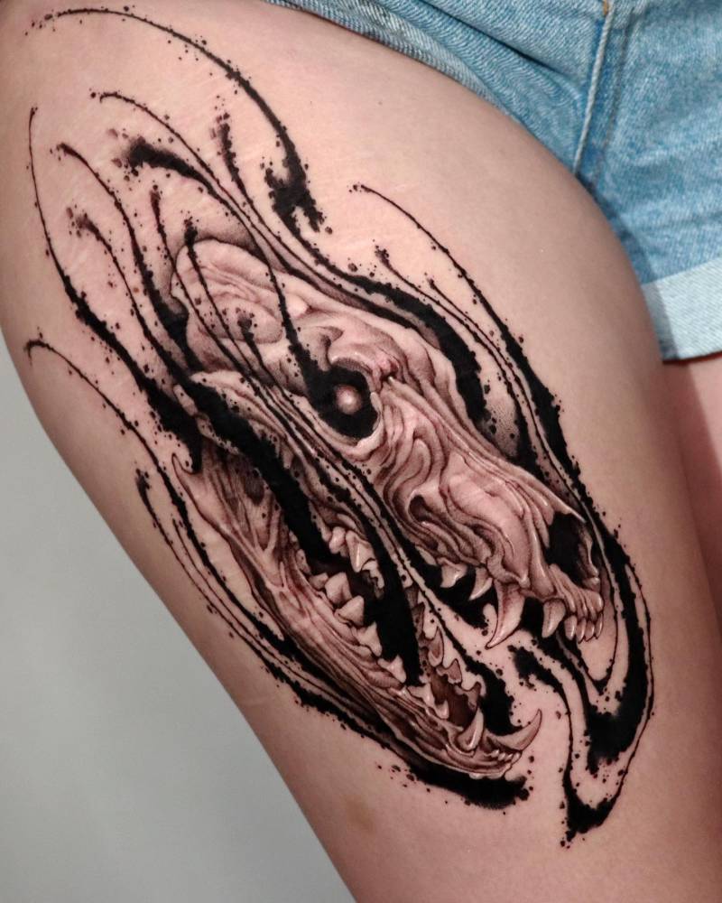 Wolf skull tattoo in blackwork style located on the thigh.