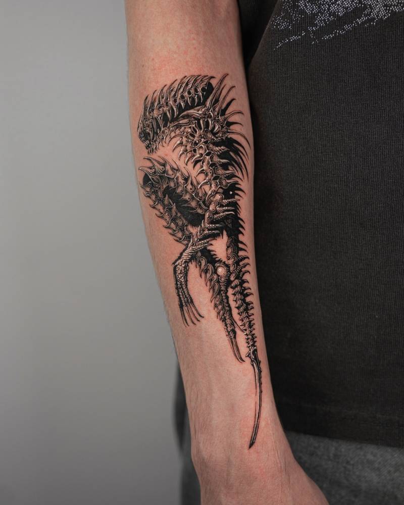 Xenomorph tattoo in illustrative style located on the forearm.