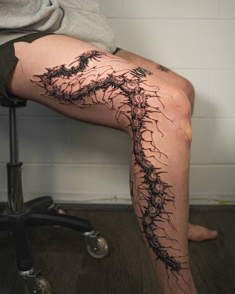 Eye centipede tattoo located on the leg, done in illustrative style.
