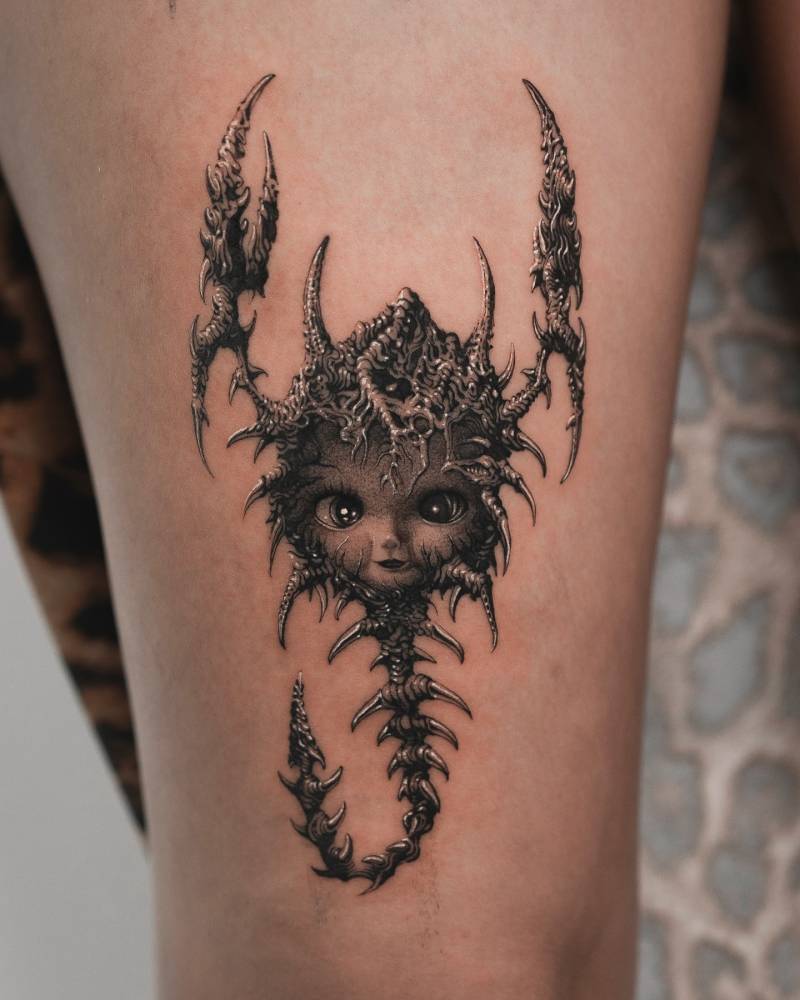 Kewpie scorpion tattoo in illustrative style located on the thigh.