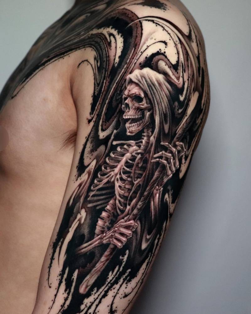 Black and grey Grim Reaper tattoo located on the upper arm.
