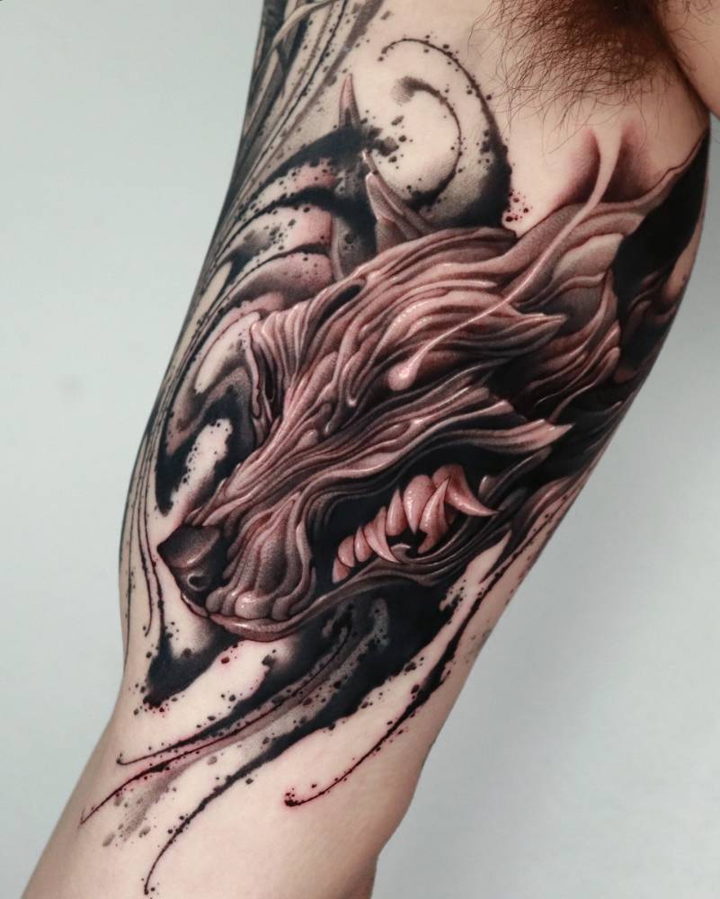 Abstract style wolf head tattoo located on the inner arm.