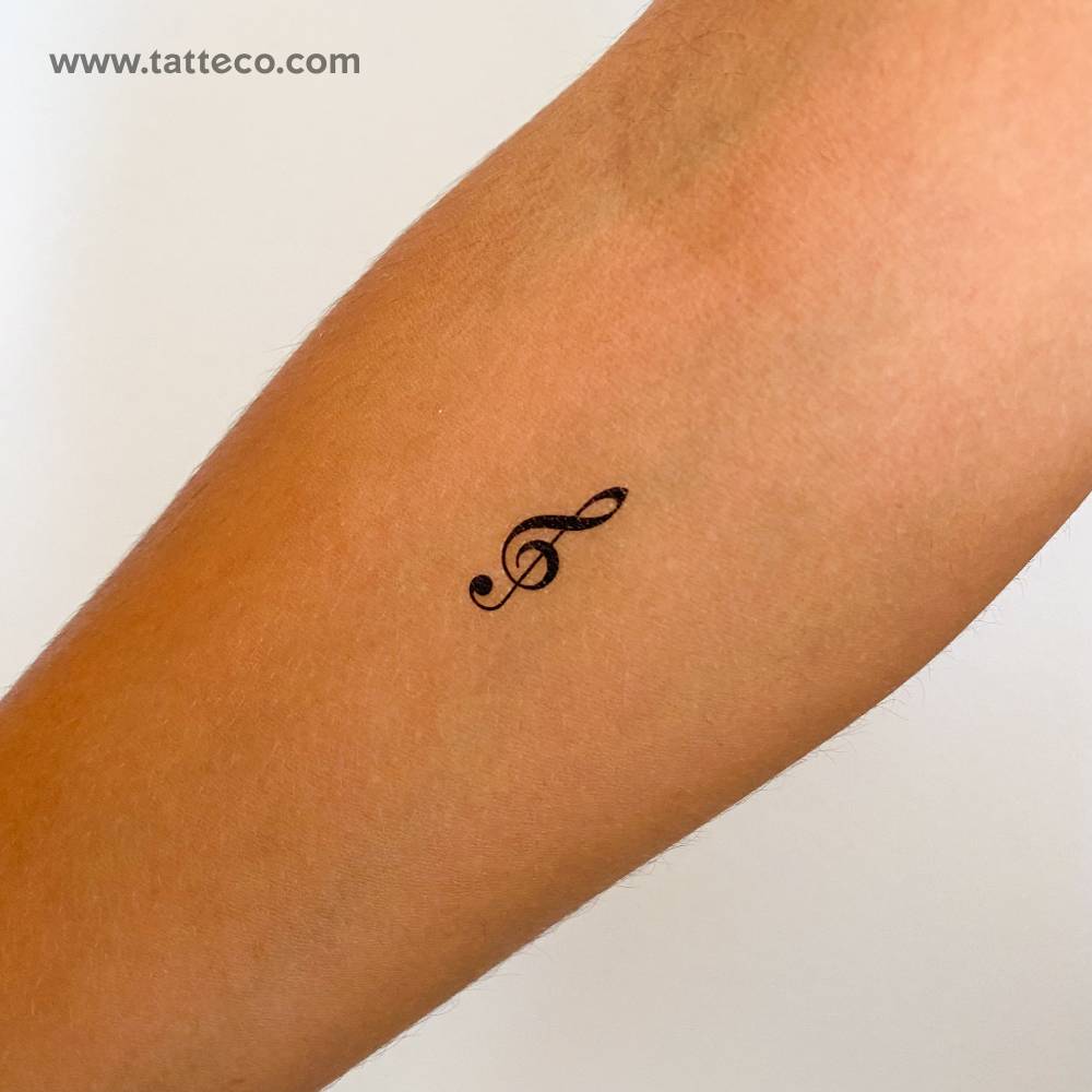 Minimalistic style treble clef temporary tattoo located on the inner forearm.