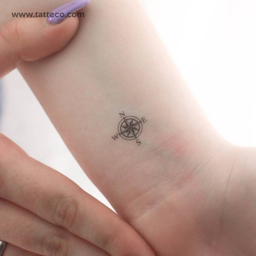 Tiny compass rose temporary tattoo located on the wrist.