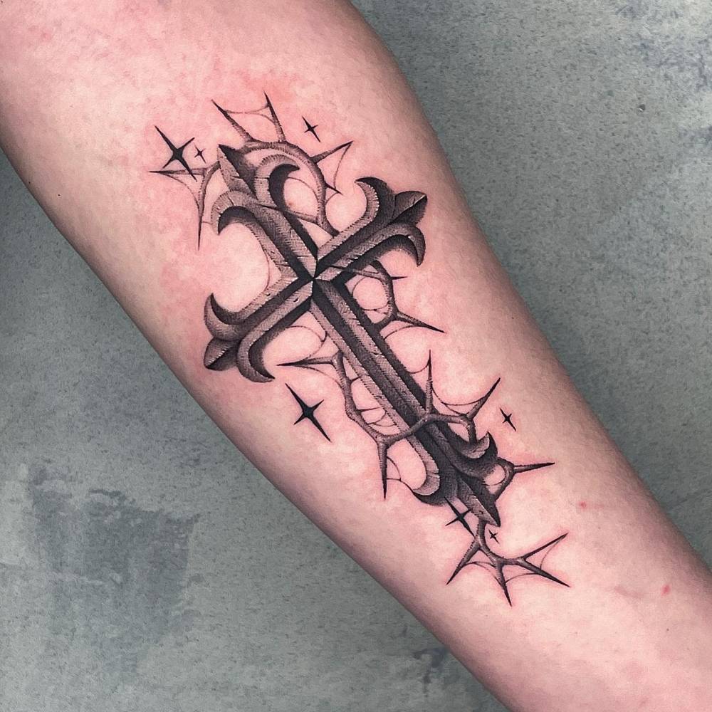Cross and thorns tattoo located on the inner forearm.