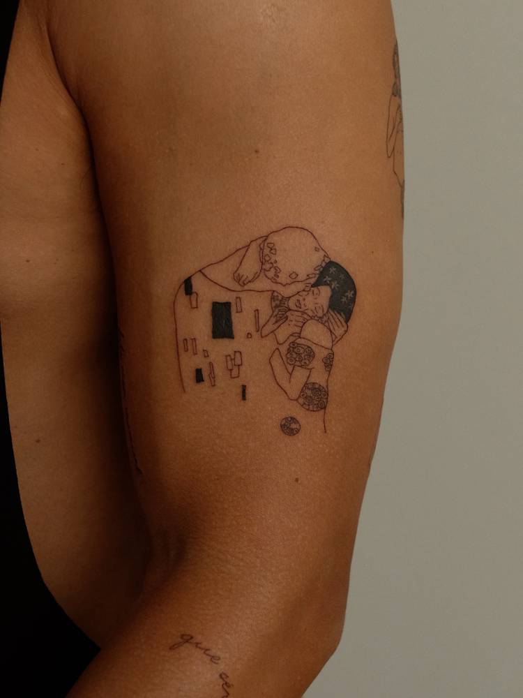 Klimt's 'The Kiss' tattoo located on the upper arm.