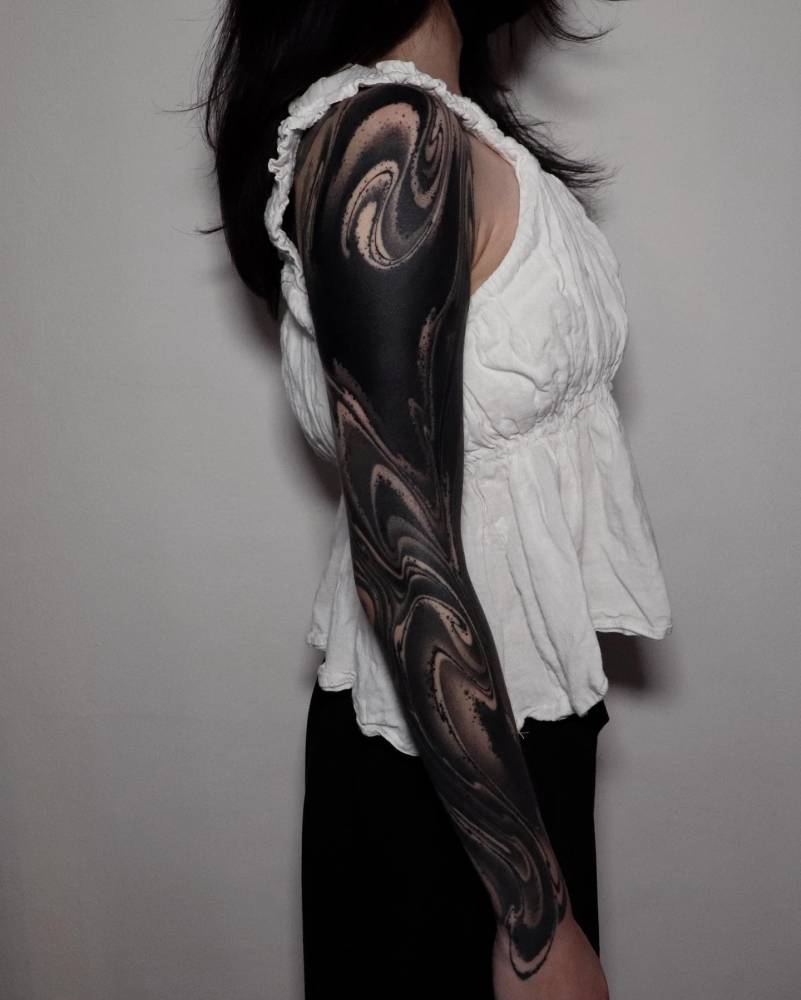 Abstract sleeve tattoo in blackwork style.