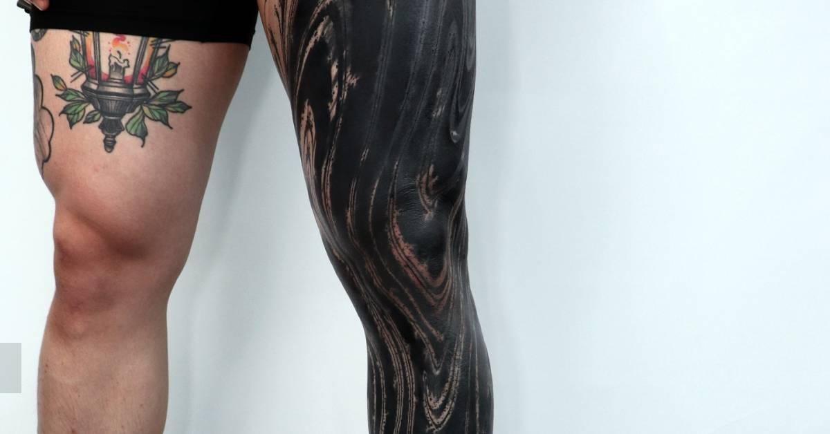 Blackwork style abstract leg sleeve tattoo.