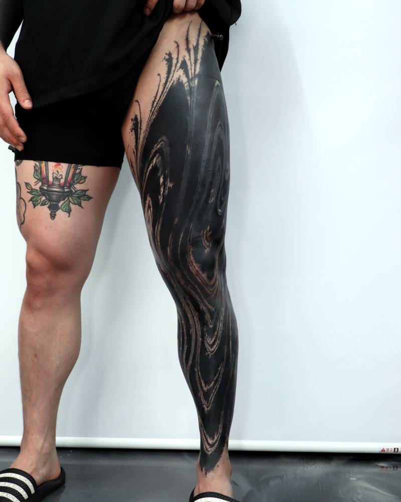 Blackwork style abstract leg sleeve tattoo.