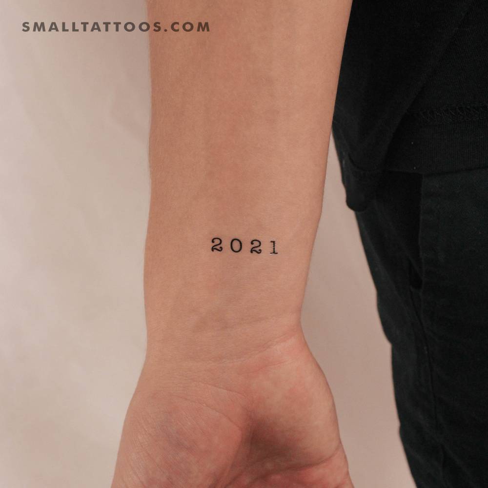 Typewriter font "2021" birth year temporary tattoo located on the wrist.
