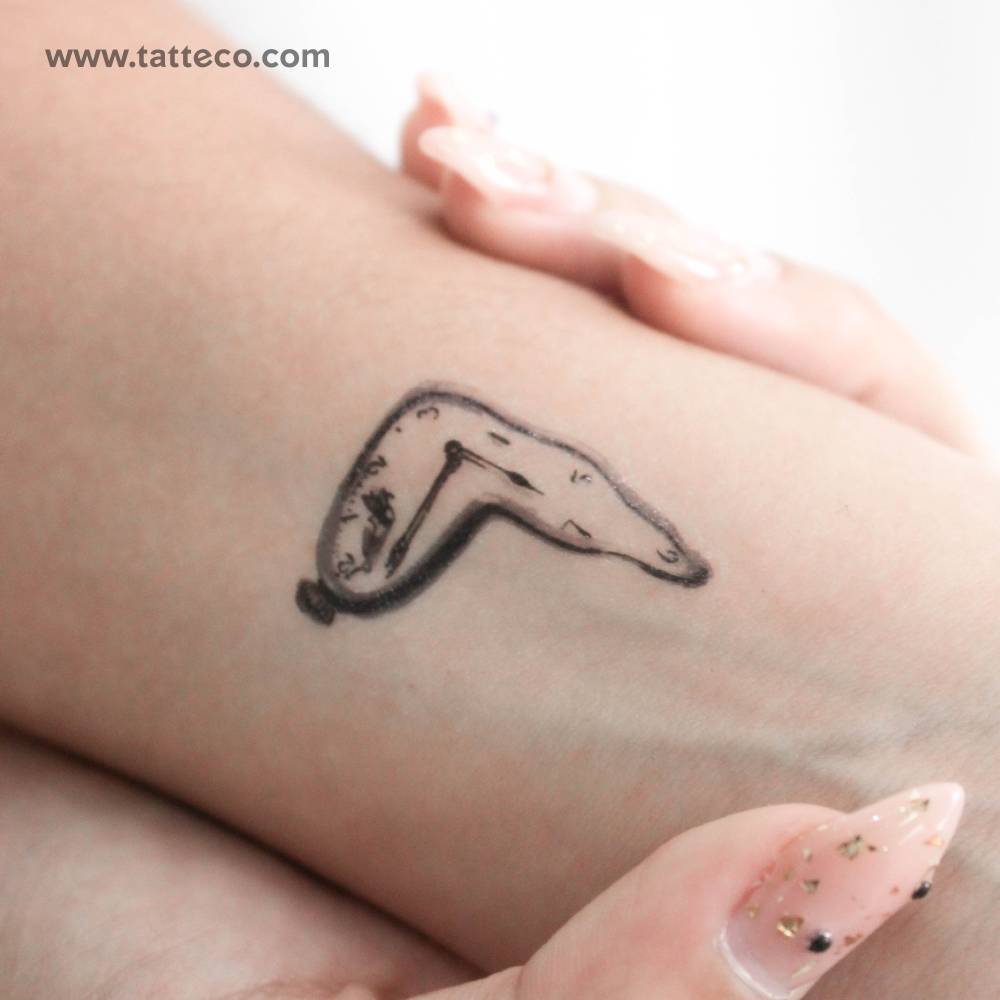 Watercolor style melting clock temporary tattoo done on the wrist.