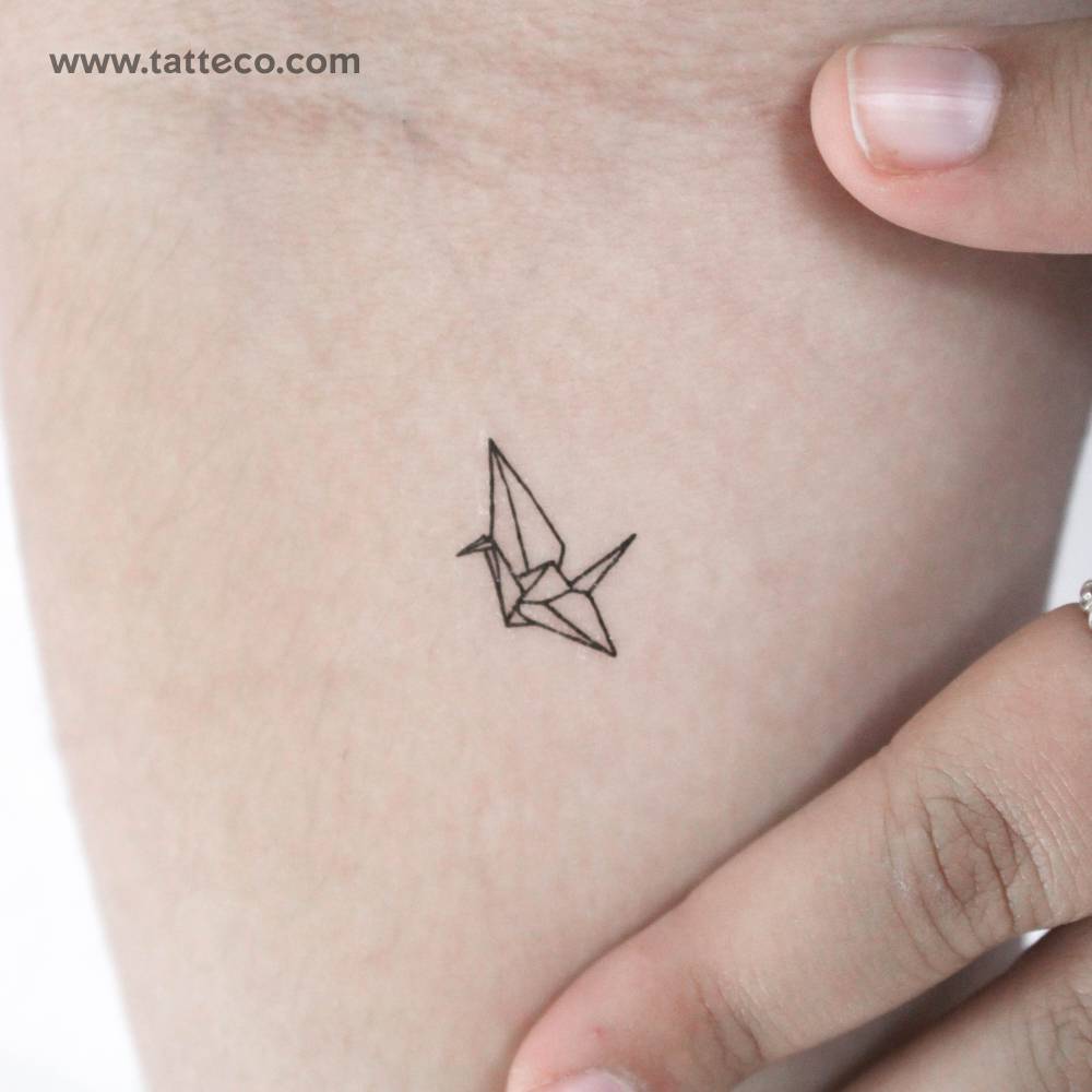 Tiny fine line style origami crane temporary tattoo located on the inner forearm.