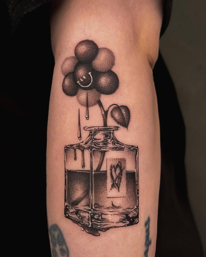 Dotwork style flower in a bottle tattoo located on the forearm.