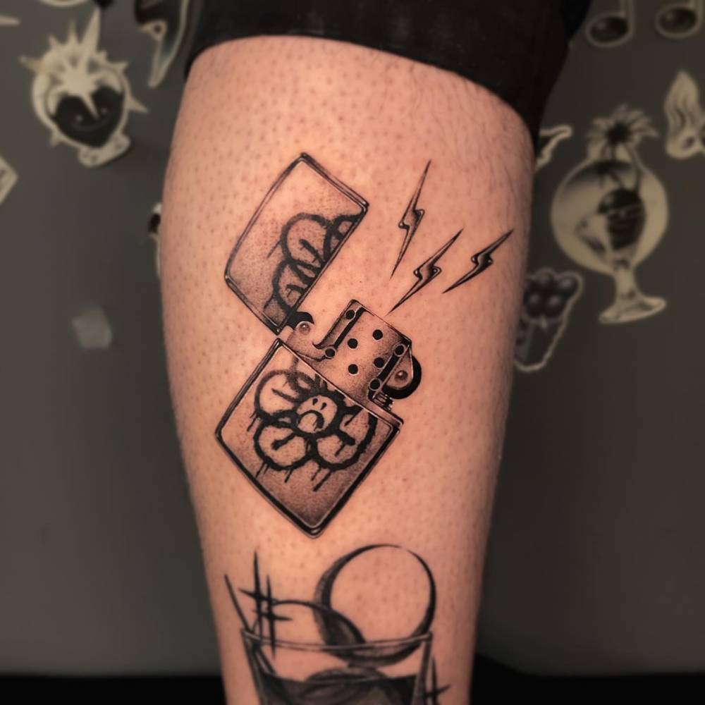 Black and grey lighter tattoo located on the calf.