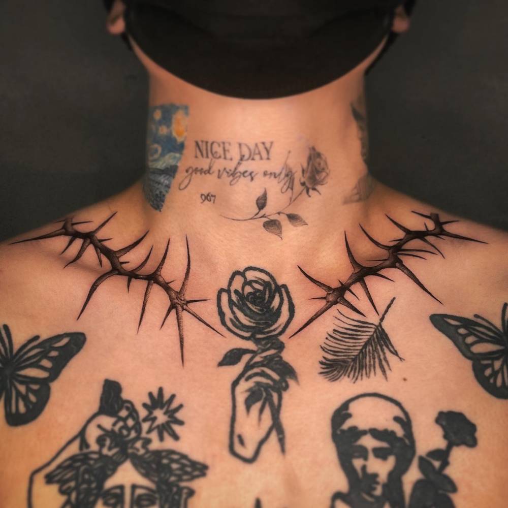 Individual matching black and grey thorns tattooed on the collarbones.