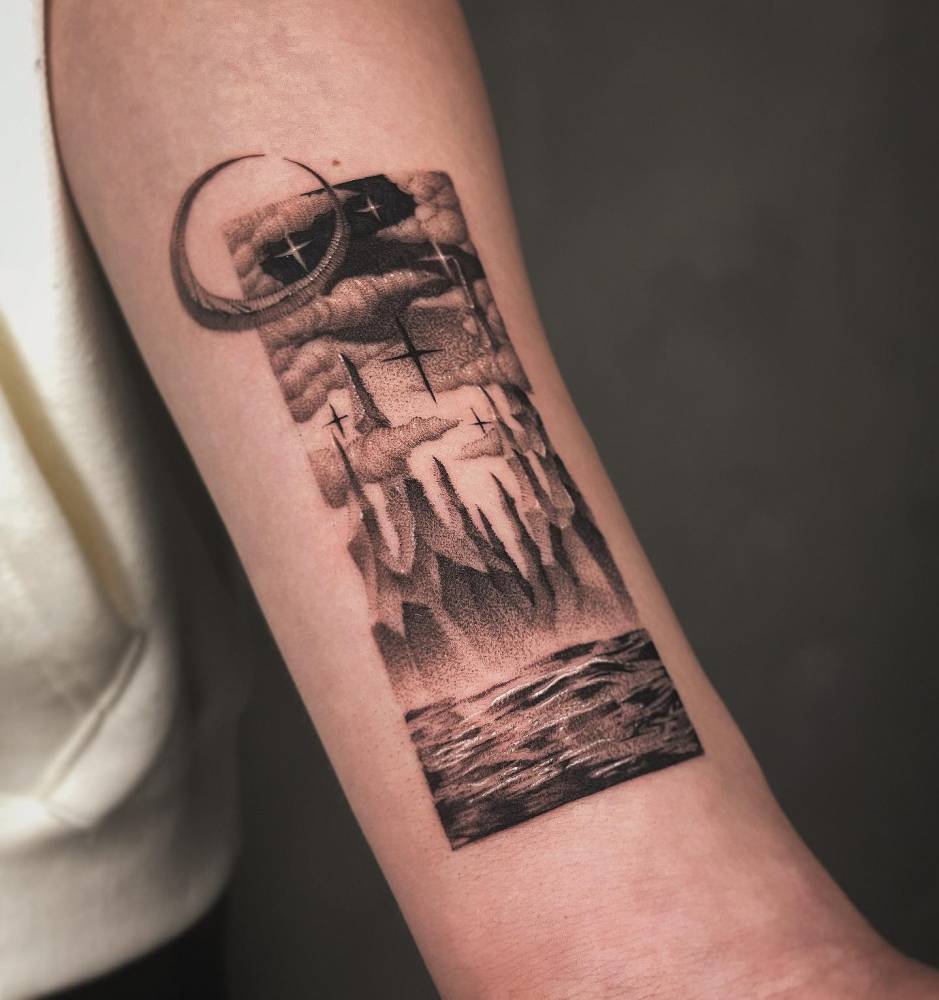 Dotwork style sea and mountain landscape tattoo located on the bicep.
