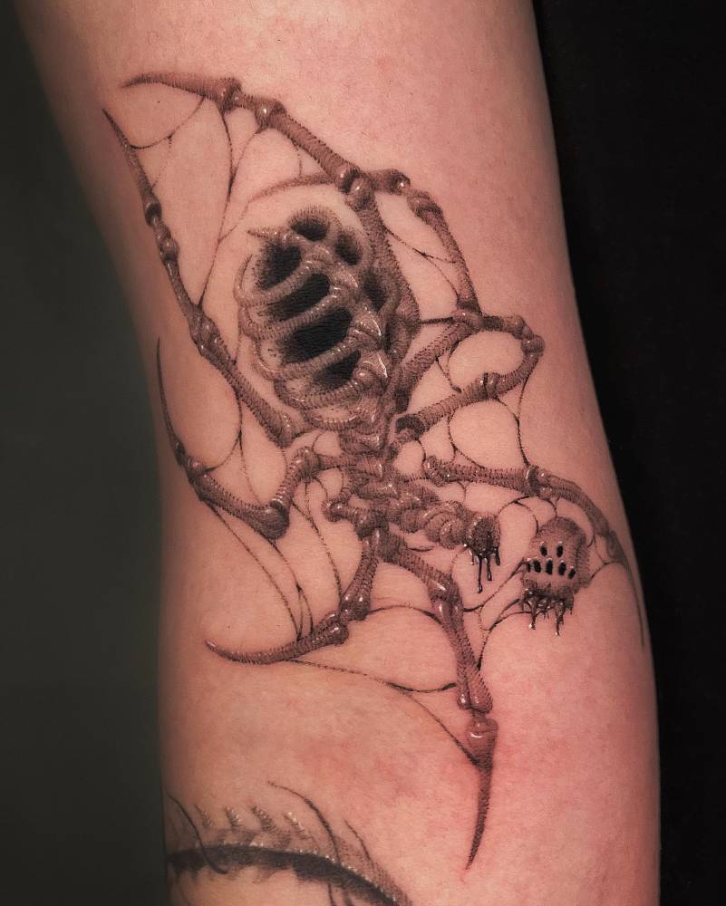 Illustrative style skeleton spider tattoo located on the bicep.