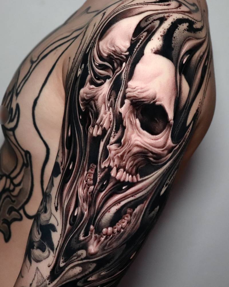 Abstract skull tattoo located on the upper arm.