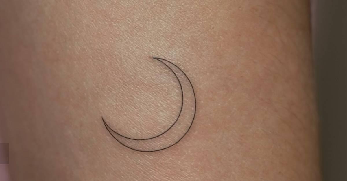 Fine line style crescent moon tattoo located on the