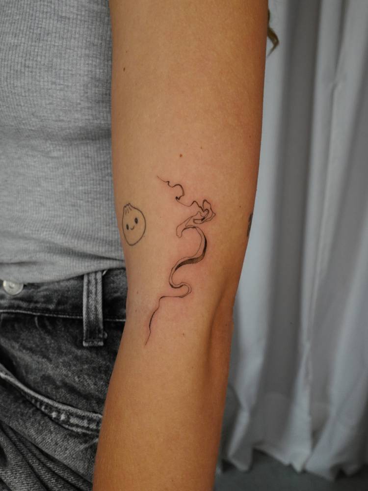 Smoke tattoo in illustrative style located on the upper arm.