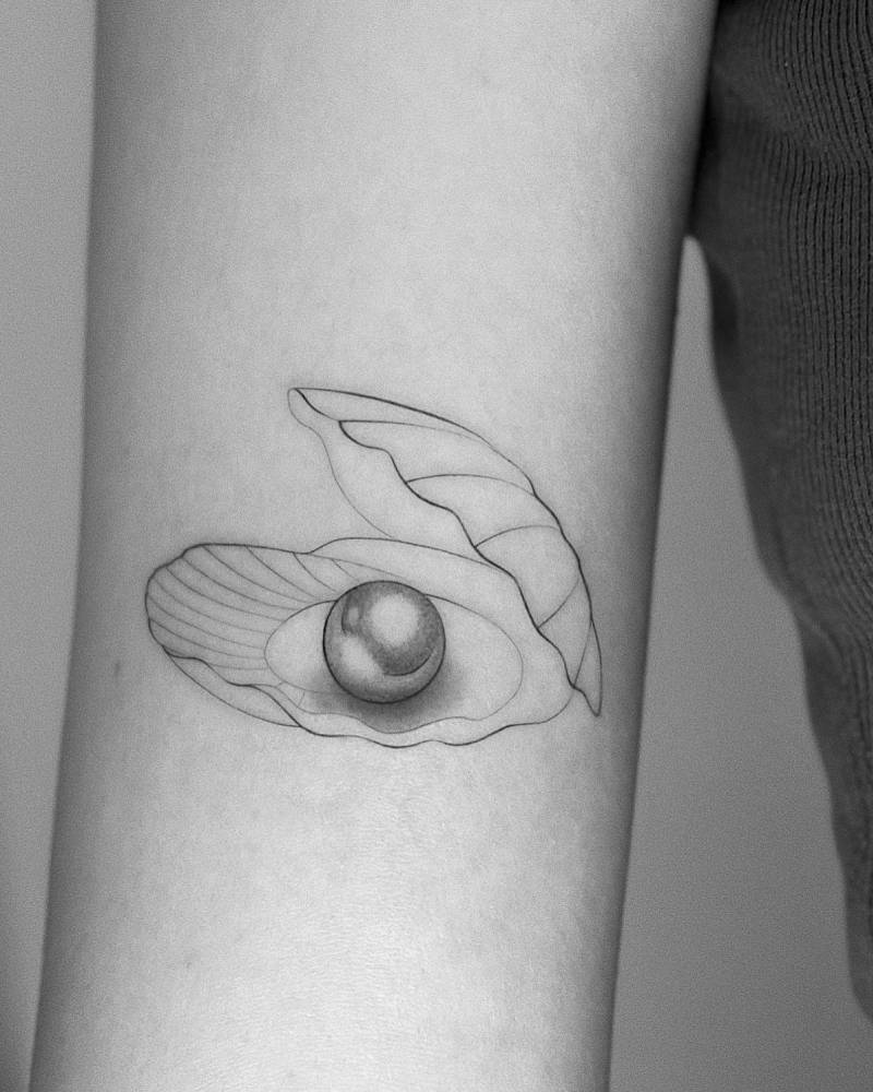 Illustrative style scallop tattoo located on the bicep.