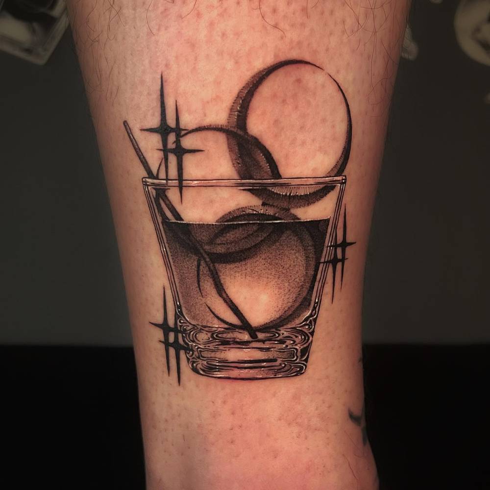 Moon cocktail tattoo located on the shin, illustrative style.