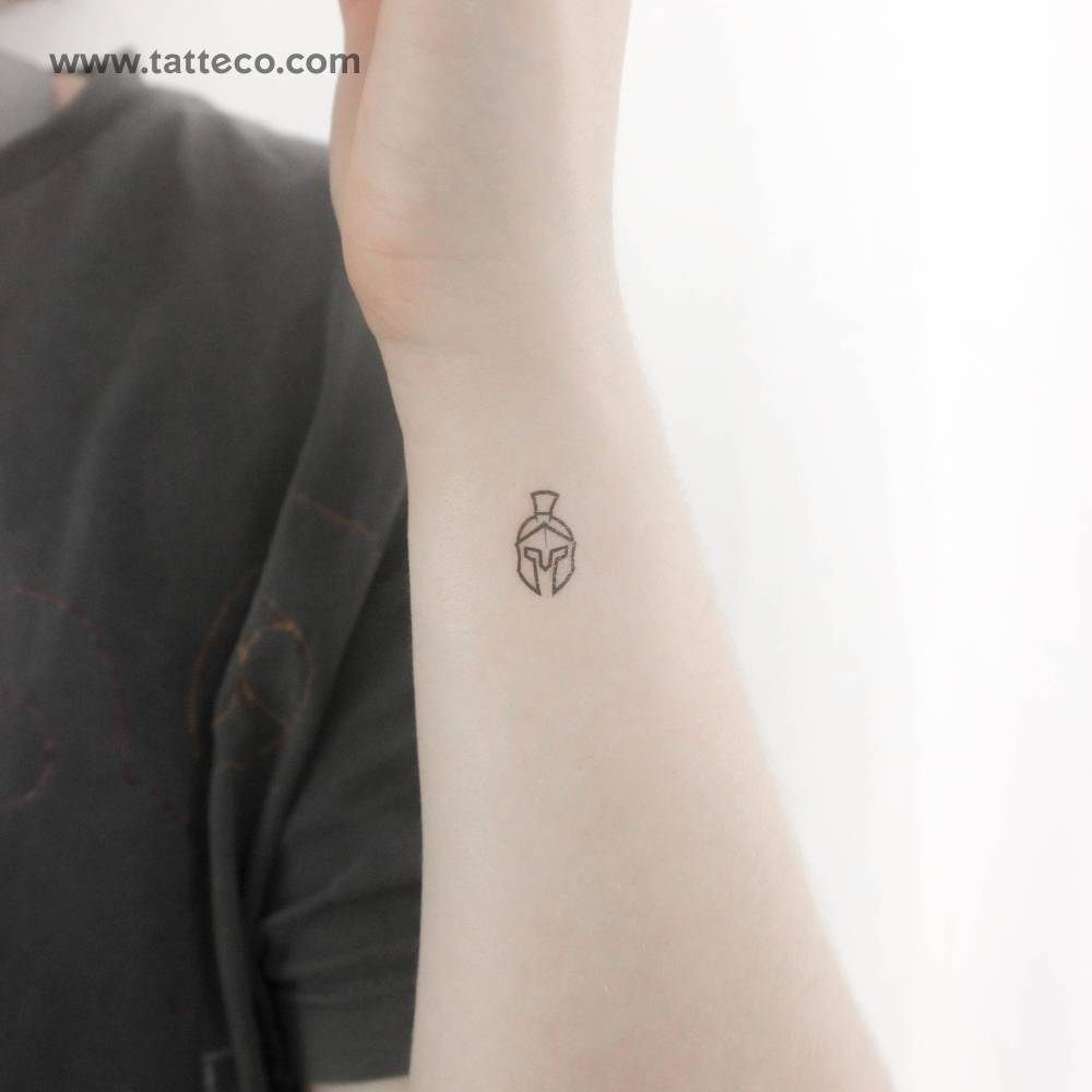 Tiny minimalistic Spartan helmet temporary tattoo located on the wrist.