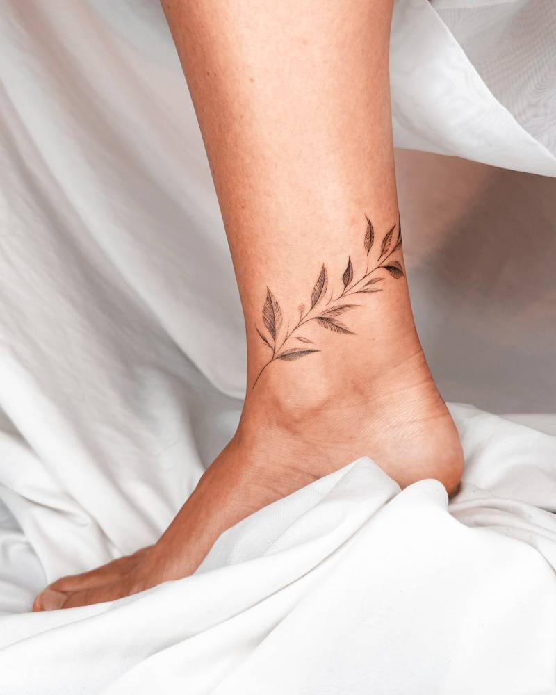 Leaves anklet tattoo in illustrative style.
