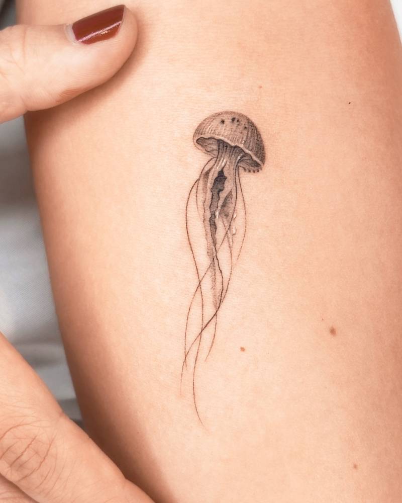Jellyfish tattoo placed on the inner forearm, done in illustrative style.