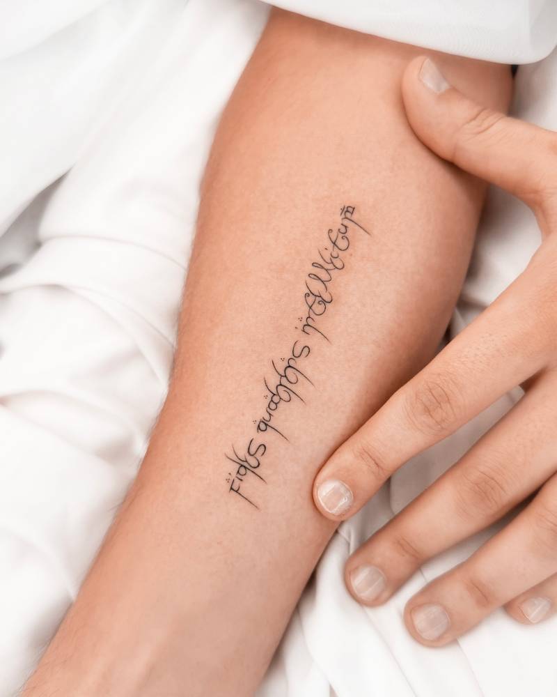 Elvish lettering tattoo located on the inner forearm.
