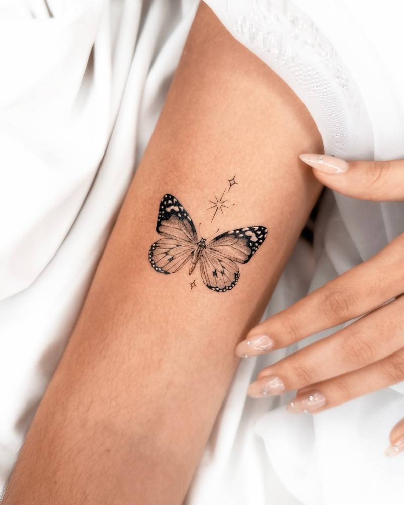 Butterfly tattoo in micro-realistic style placed on the upper arm.