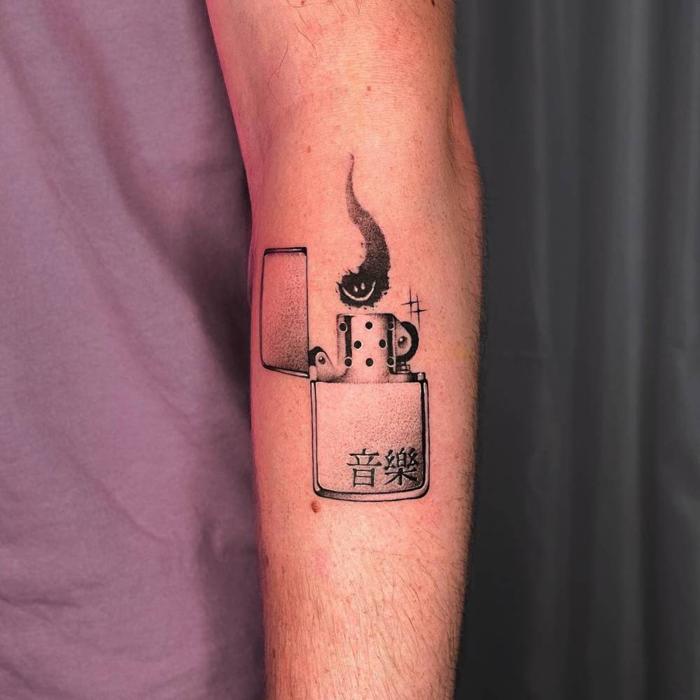 Black and grey style lighter tattoo located on the forearm.