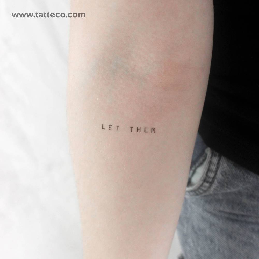 Uppercase "let them" temporary tattoo located on the inner forearm.