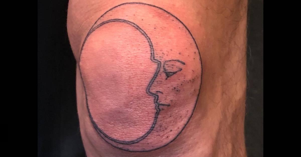 Moon face tattoo in illustrative style located on the