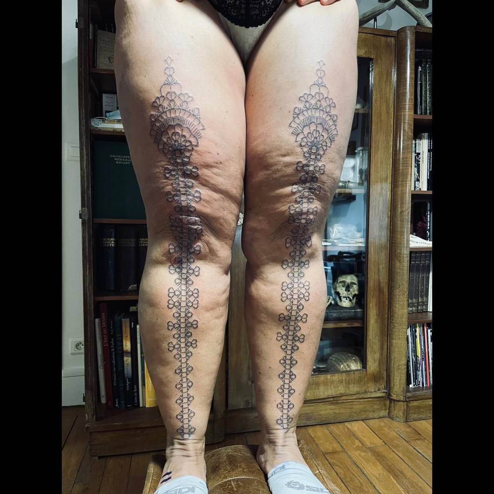Individual matching ornamental designs tattooed on the legs.