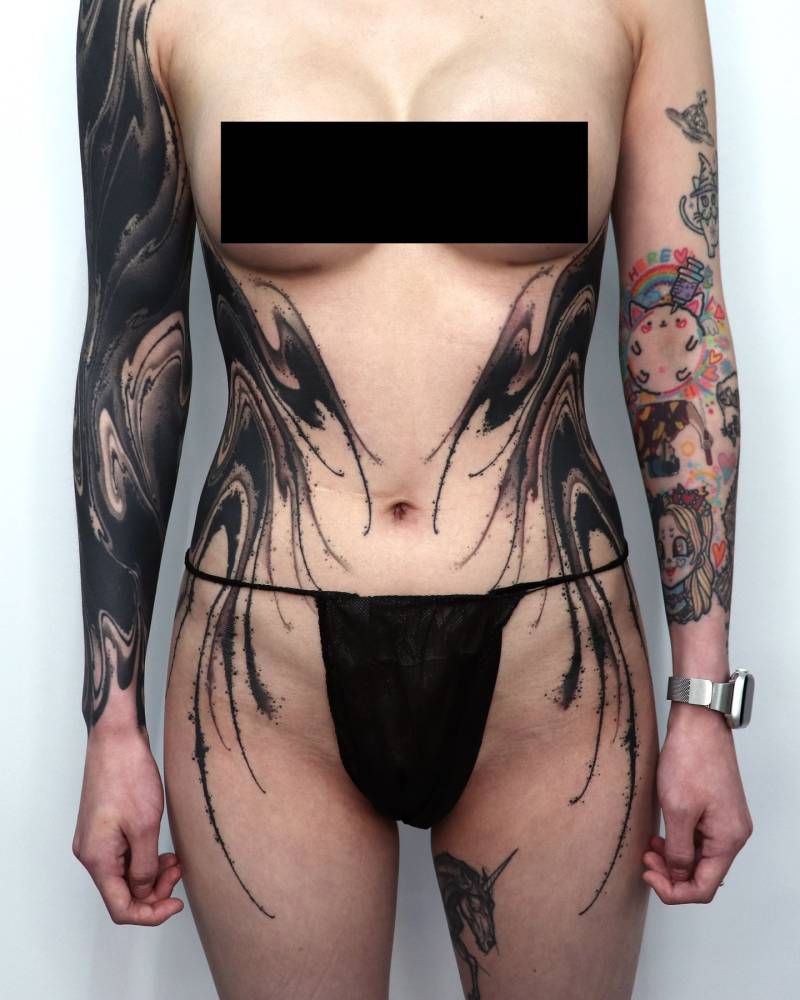 Individual matching abstract flow design tattooed on the waist.