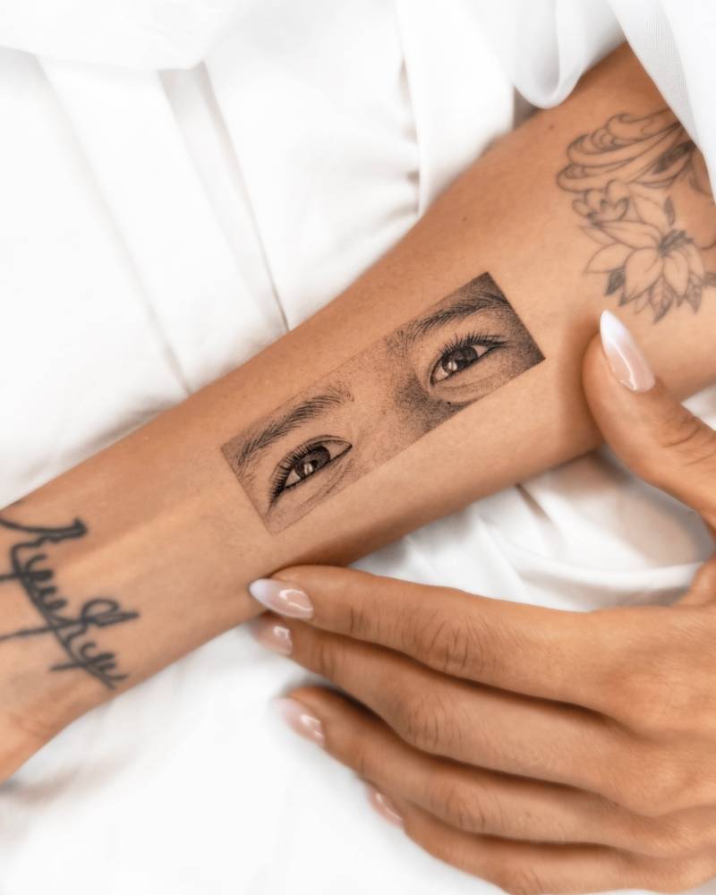 Black and grey eyes tattoo located on the inner forearm.
