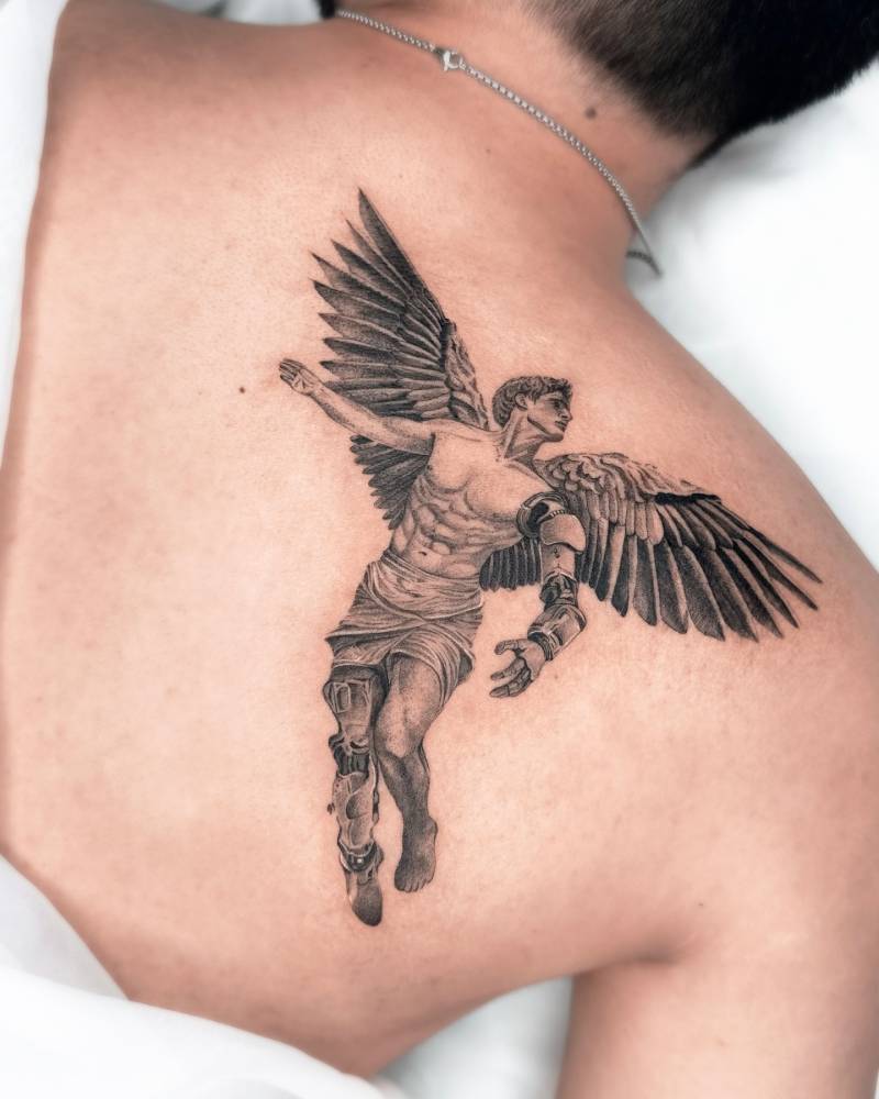 Icarus tattoo in black and grey style located on the shoulder blade.
