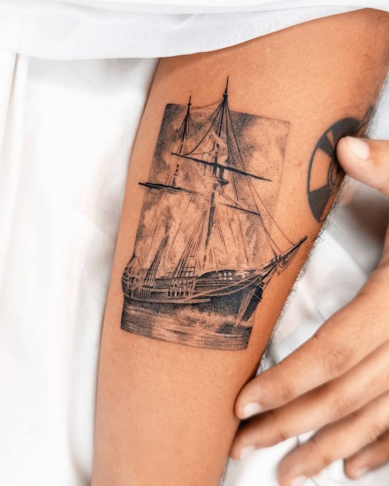 Micro-realistic style sailing ship tattoo placed on the inner forearm.