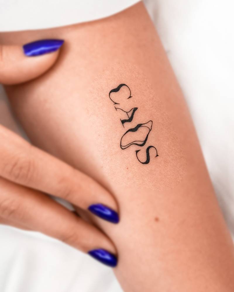 Lettering tattoo of the word "caos" located on the inner arm.