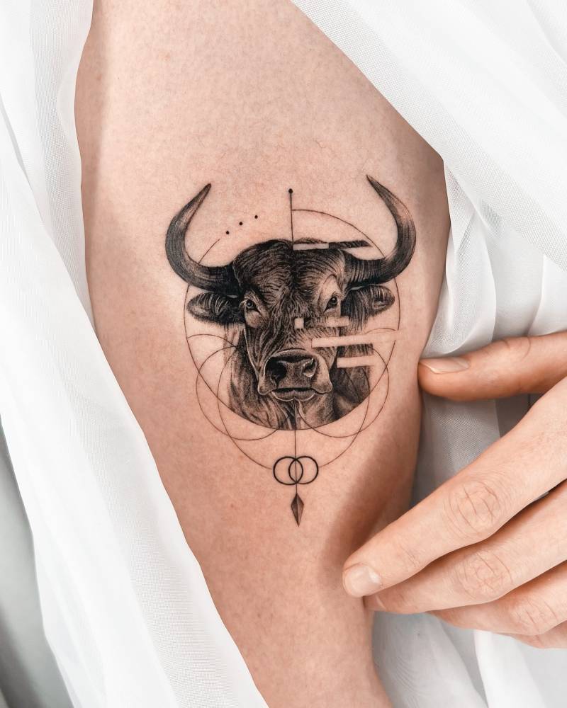 Bull portrait tattoo in micro-realistic style located on the upper arm.