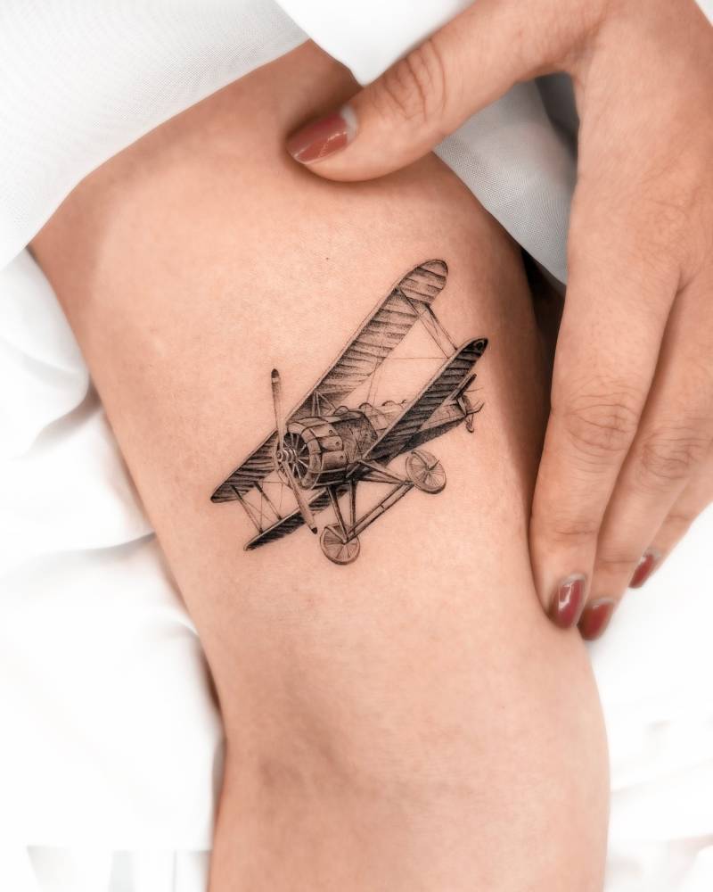 Light aircraft tattoo in micro-realistic style located on the inner arm.