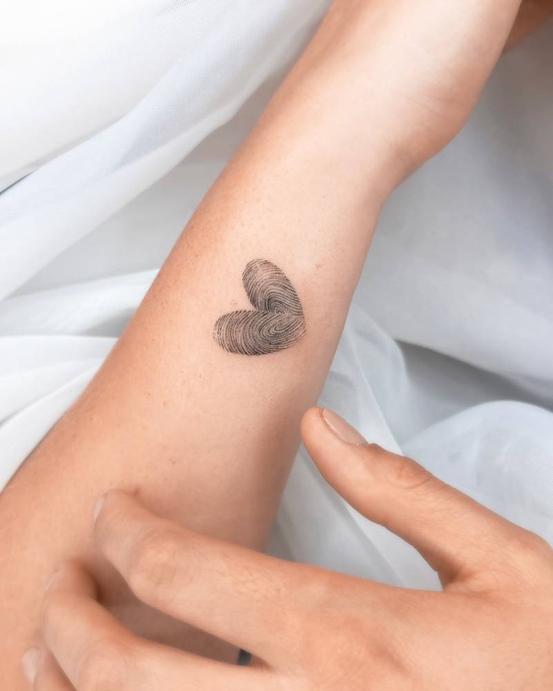 Heart fingerprint tattoo in micro-realistic style.