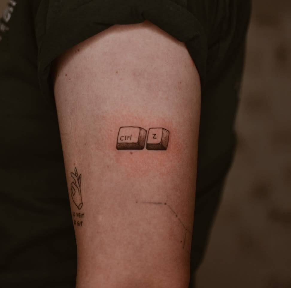 "Ctrl + Z" tattoo located on the upper arm.