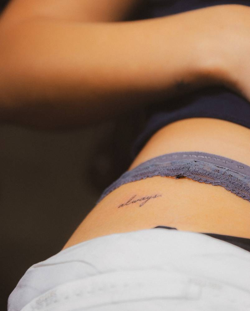 Handwritten font word "always" tattooed on Olivia Holt's hip.