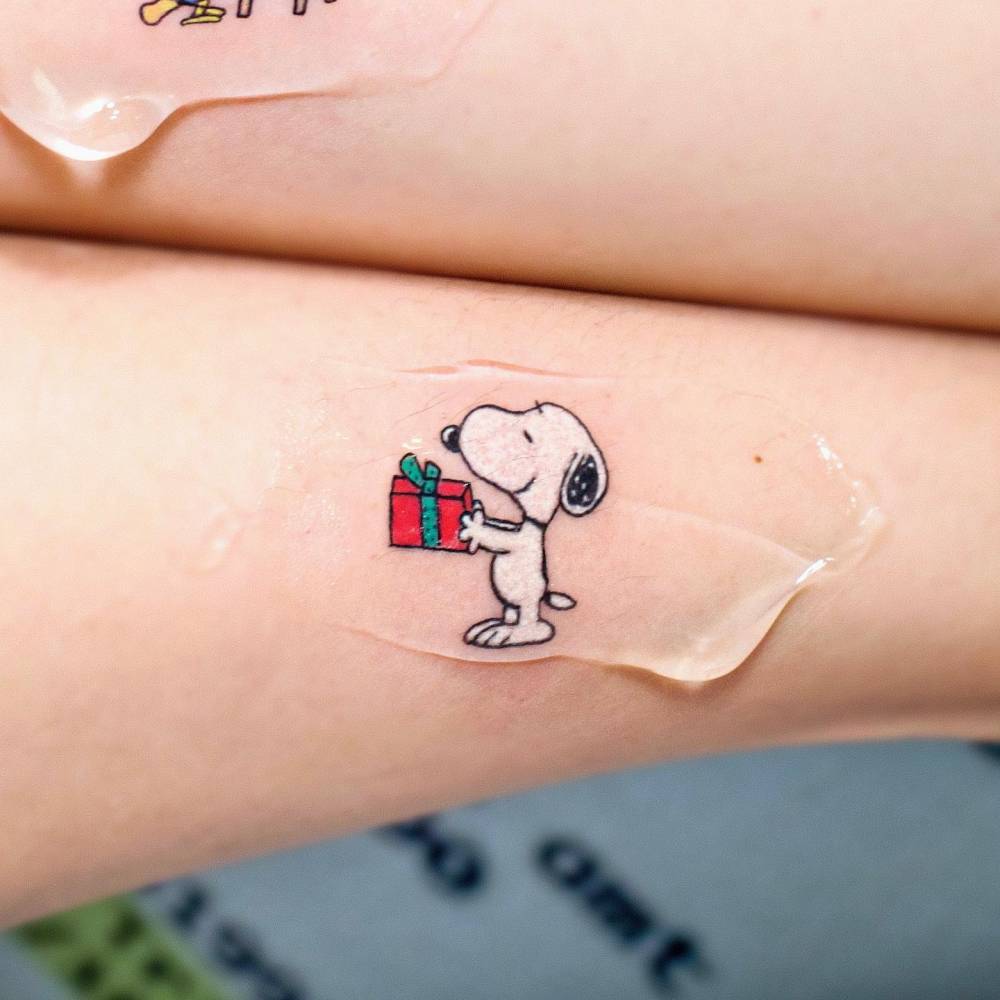 Snoopy tattoo located on the forearm.