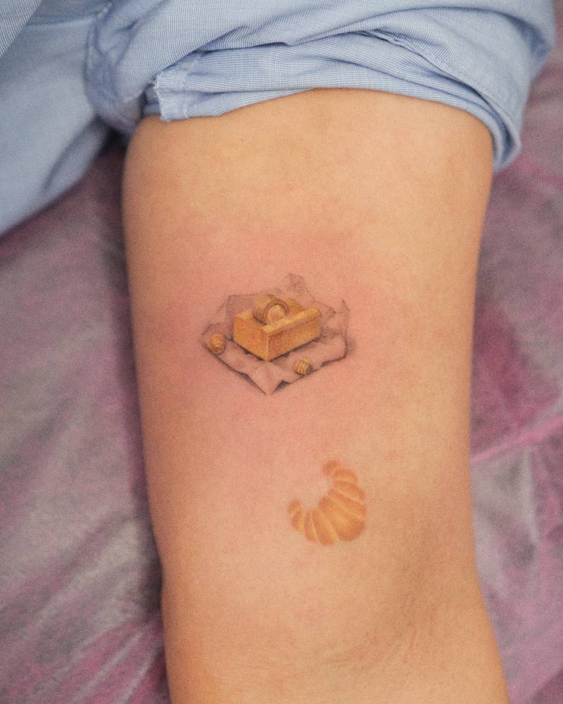 Butter tattoo in micro-realistic style done on the inner arm.